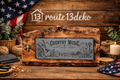 Schieferplatte mit Country-Music-Schriftzug, Gitarre und Cowboyhut auf rustikalem Fichtenholzbrett

